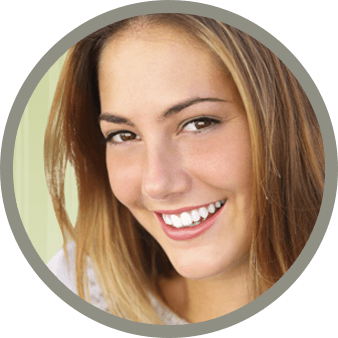 A young woman smiles in front of a green backdrop.